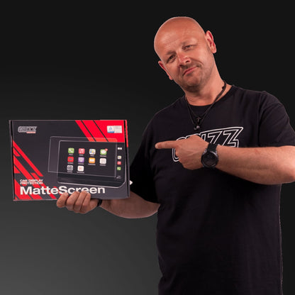 Bald man in black shirt points to a GrizzProtector matte Displayschutzfolie box for Nissan Juke 2 9", against dark backdrop.